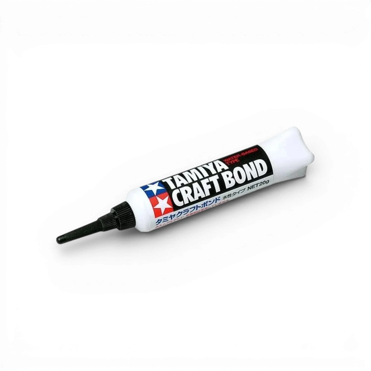Colle Tamiya Craft Bond, accessoire pour bricolage, application visible sur le tube en plastique blanc.