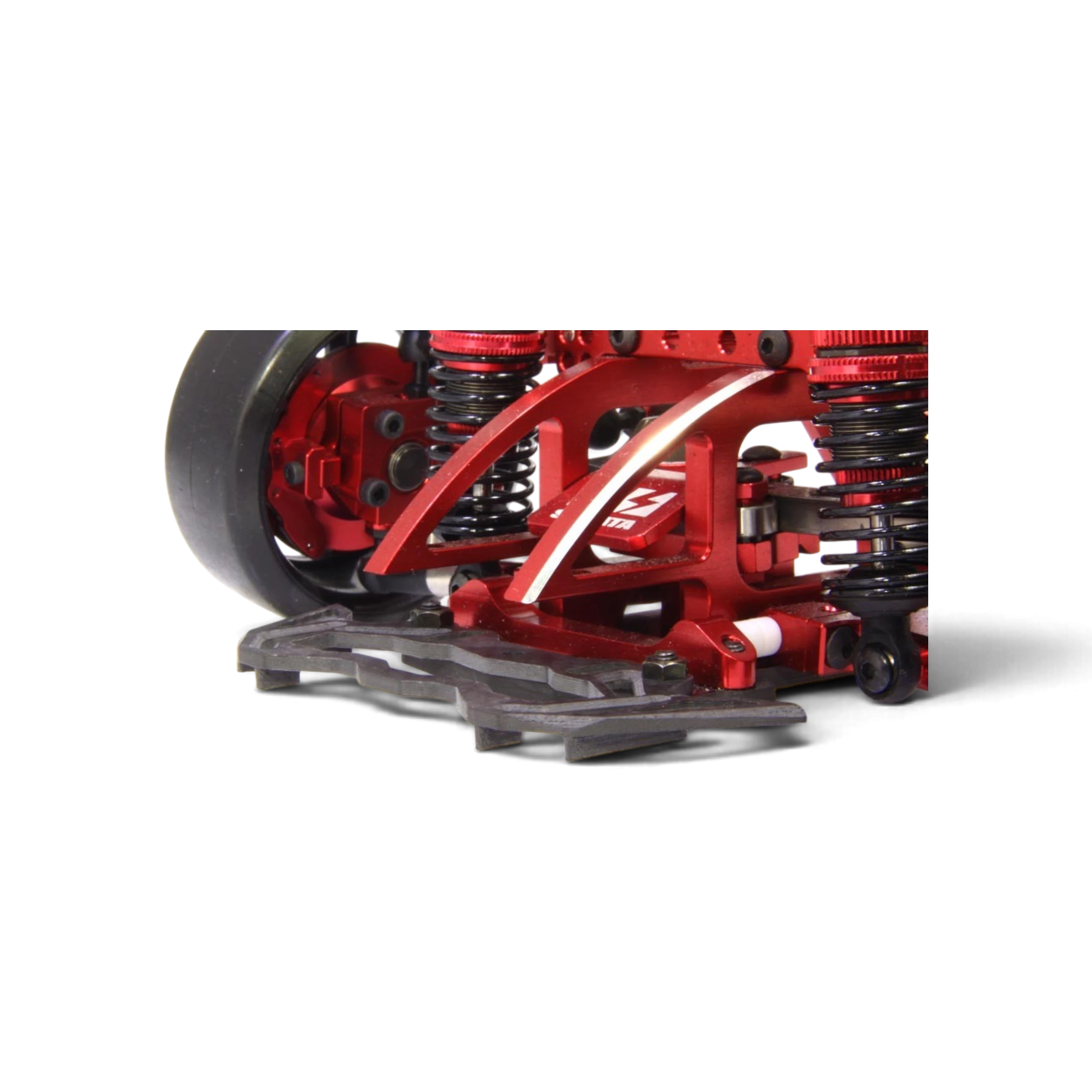 Pare-chocs DriftParadiZ en carbone mat avec ailettes aérodynamiques monté sur un châssis RC drift rouge