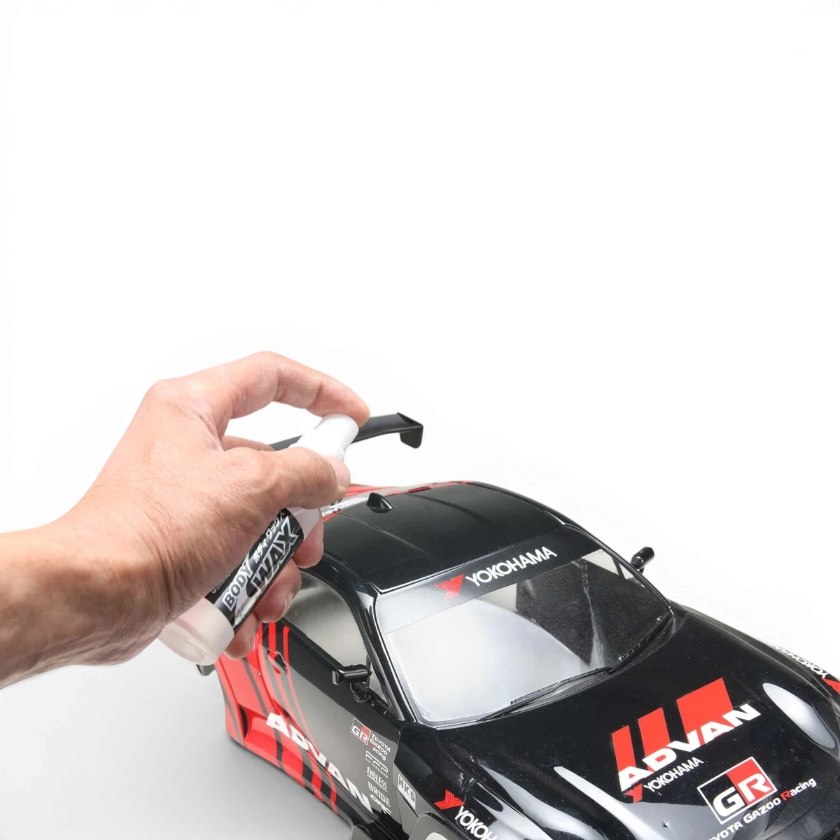 Nettoyant et cire pour carrosserie Muc-off, application sur une voiture de drift, finition propre et brillante visible.
