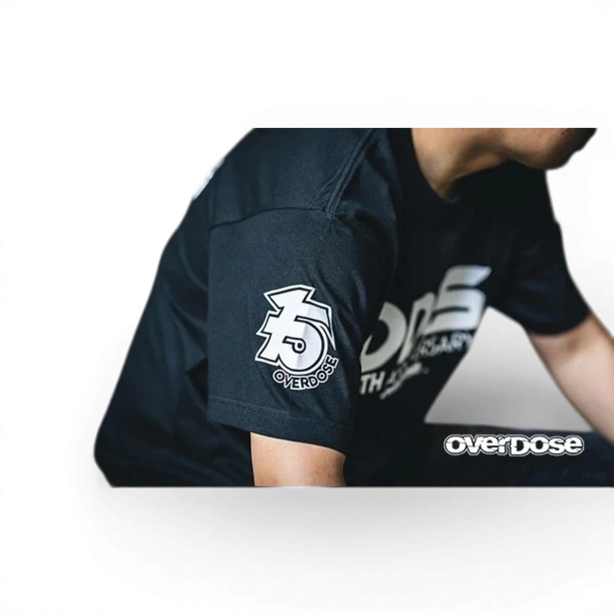 T-shirt Overdose 15th Anniversary avec logo et design spécial, en coton noir, porté par un mannequin.