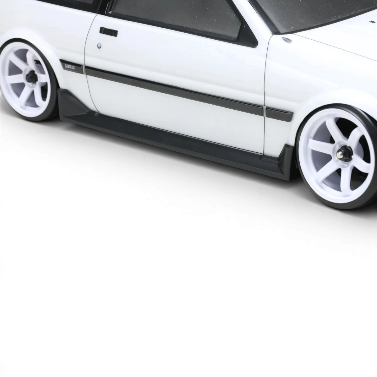 Carrosserie pour Toyota Corolla AE86 Levin 2 portes, kit aéro de la marque Team Yokomo, vue de face sur voiture blanche