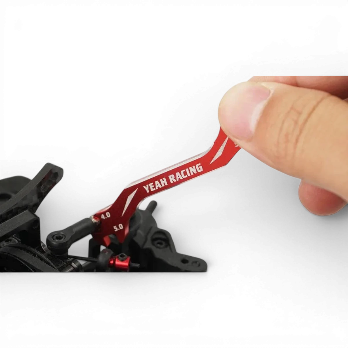 Clé biellette Yeah Racing pour accessoires de drift, en métal avec design robuste, posé sur une surface noire.