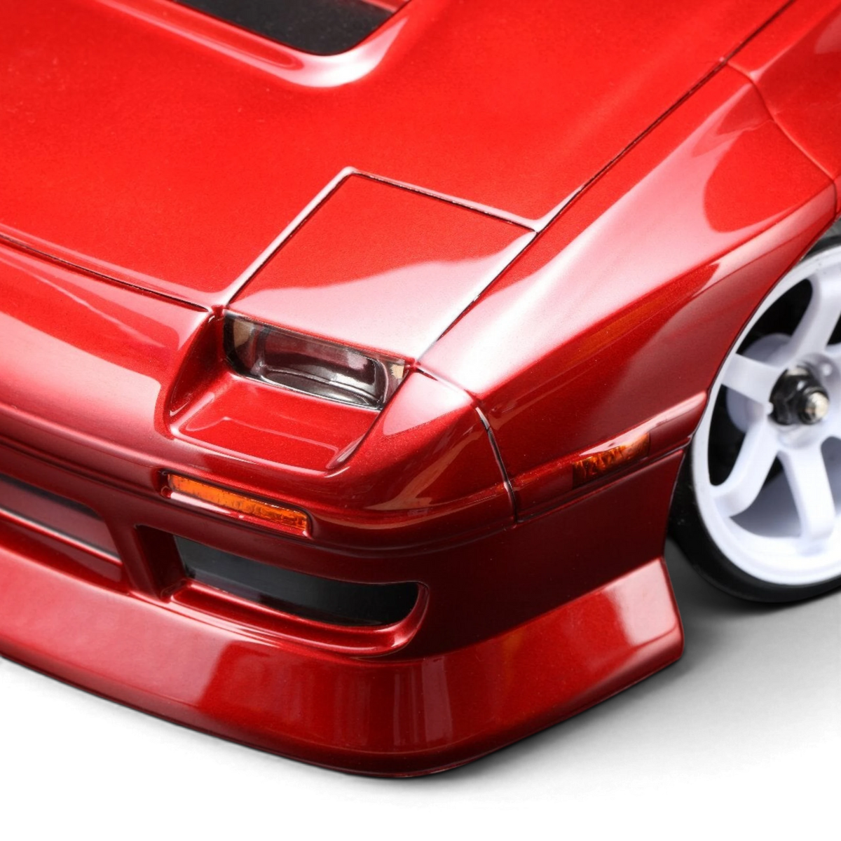 Gros plan sur la carrosserie rouge DriftParadiZ Mazda RX-7 FC3S BN Sports avec jantes blanches pour châssis RC Drift