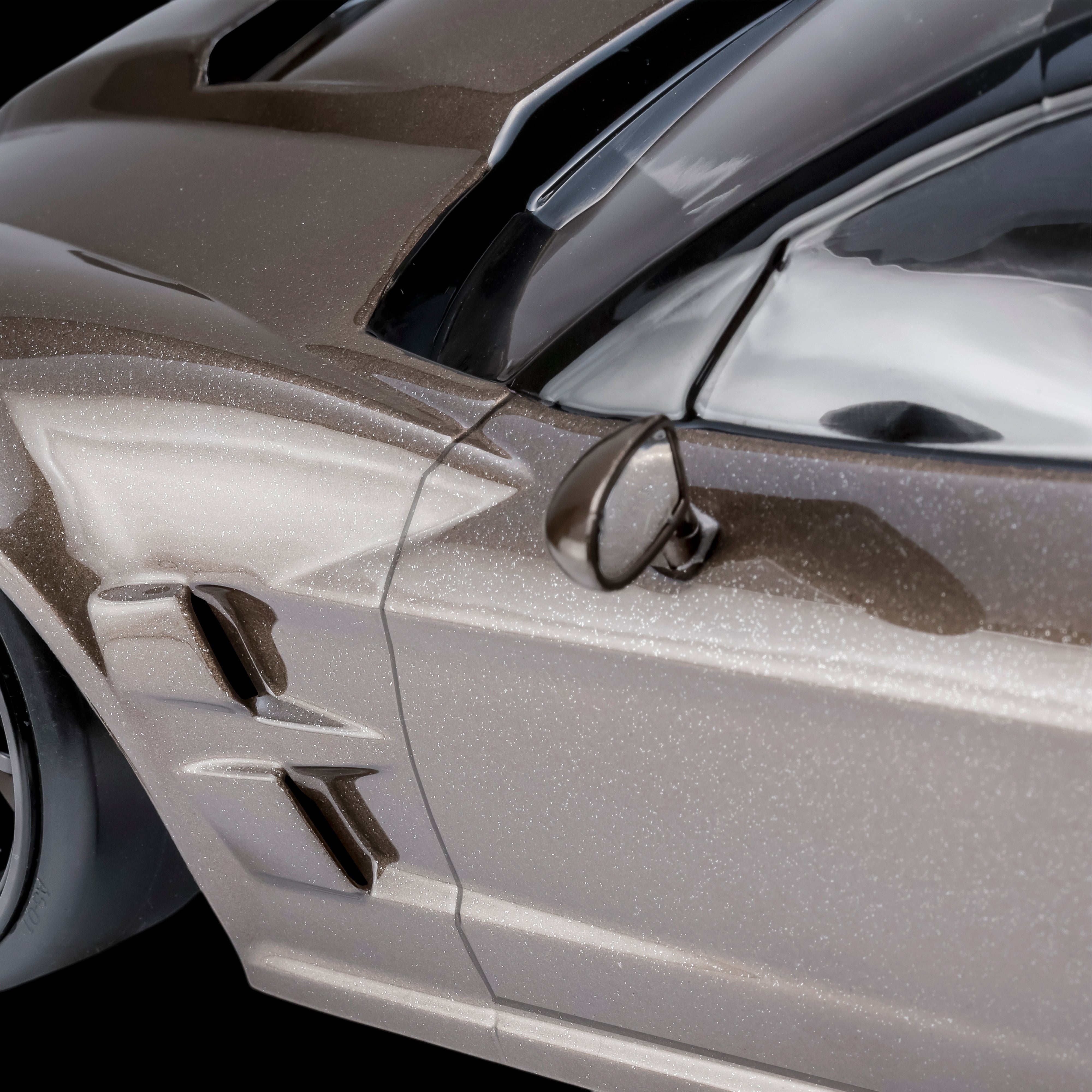 Gros plan sur la carrosserie DriftParadiZ Corvette GT2 marron pailleté avec rétroviseur et détails aérodynamiques
