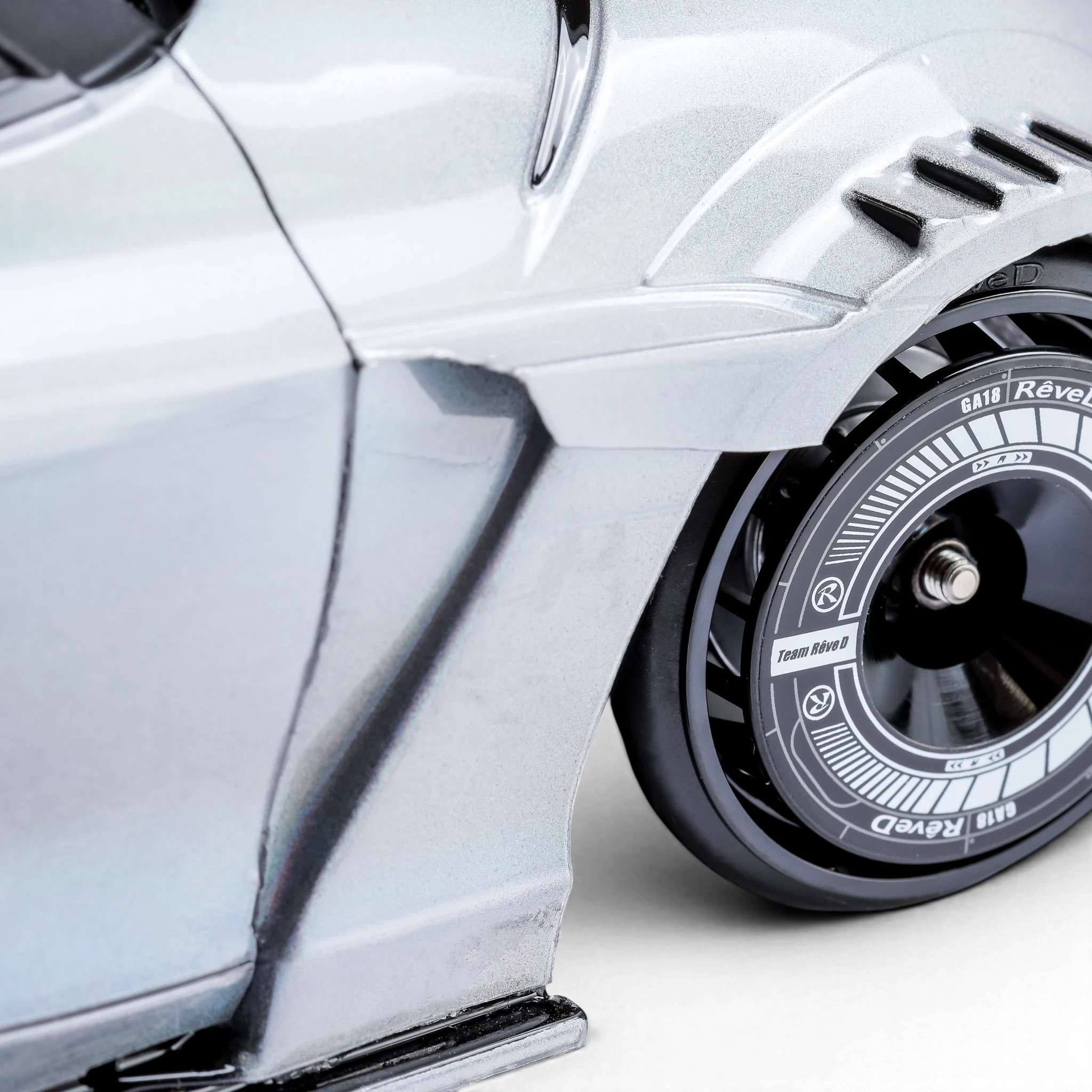 Stickers pour jantes DriftParadiZ RW-GA18 installés sur une voiture RC argentée pour un look racing de compétition