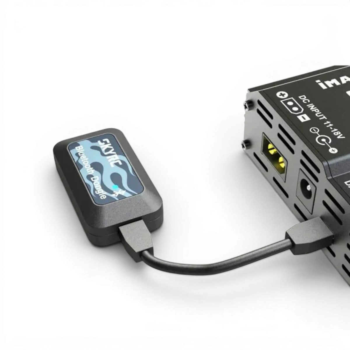 Module dongle Bluetooth SkyRc pour électronique Sky600135, connecté à un appareil électronique, en vue de proximité.