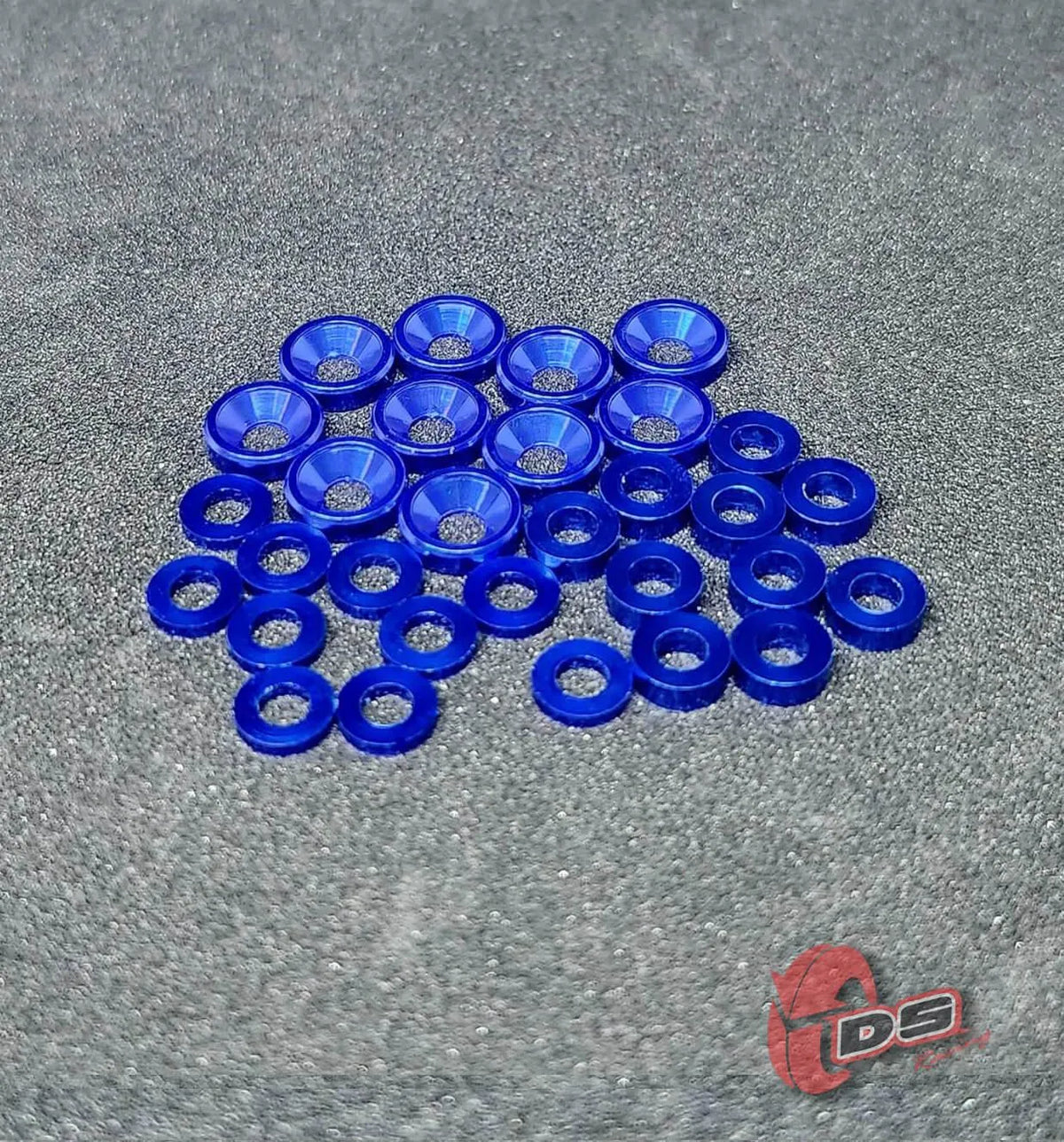 Ensemble de rondelles DS Racing, pièces détachées pour ajustements mécaniques, avec plusieurs rondelles métalliques visibles.